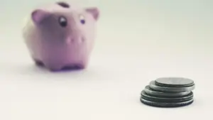 Sparschwein und Münzen auf hellem Hintergrund als Symbol für regelmäßiges Sparen mit einem ETF-Sparplan