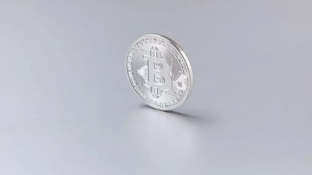 Silberne Bitcoin-Münze auf grauem Untergrund