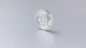 Silberne Bitcoin-Münze auf grauem Untergrund