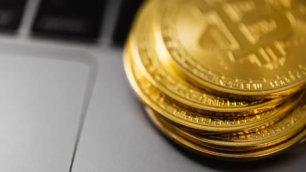 Stapel goldener Bitcoin-Münzen auf einer Laptop-Tastatur